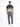 A man stands with his back to the camera, wearing gray cargo jeans and a gradient t-shirt.