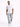 A man walks confidently in distressed light blue cargo jeans paired with a white graphic t-shirt and sneakers.
