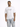 A man stands wearing a white oversized t-shirt and light blue distressed cargo jeans, showcasing a casual style.