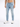 Light blue skinny jeans with distressed details, paired with white athletic shoes, worn by a male model.