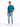 A man stands confidently in light blue distressed jeans, paired with a teal t-shirt and white sneakers.