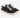 Black canvas sneakers with white laces and a textured finish, featuring a low-profile design and rubber sole.