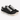 Black canvas sneakers with white laces and a textured finish, featuring a low-profile design and rubber sole.