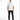 A man stands confidently in a white t-shirt and black jeans, paired with white sneakers.