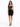 A model poses in a fitted black dress with a sheer bodice and cut-out details, paired with strappy heels.