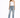 A woman poses in distressed light blue jeans with a white one-shoulder top and black high-heeled sandals.