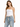 A woman stands confidently in light blue distressed jeans with a drawstring waist and a fitted white top.