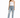 A woman stands confidently in light blue distressed jeans, paired with a fitted white top and black heels.