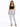 A model poses in light-wash ripped jeans paired with a black crop top and strappy heels.