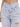 Light-wash denim jeans featuring a unique high-waisted design with pleats and distressed knee details.
