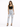 A woman stands confidently in light-wash ripped jeans paired with a black crop top and strappy heels.