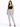 A woman stands confidently in light-wash ripped jeans and a black crop top, paired with black heels.