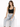 A model poses in light blue ripped jeans and a black cropped top, showcasing a casual, stylish look.