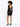 A model showcases a fitted black dress with long sleeves and an open back, paired with black high heels.