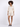 A model poses in a light beige button-up top and matching shorts, complemented by black open-toe heels.