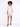 A model poses in a light beige button-up shirt and matching shorts, paired with black open-toe heels.