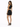 A woman stands in profile, wearing a black crop top and a fitted skirt with lace-up details, paired with black heels.