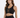 A model poses in a black cropped top with a lace-up front and gold eyelets, paired with a matching skirt.
