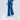 Blue wide-leg pants with an elastic waistband and side pockets, paired with white sneakers.