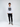 A young man stands confidently in a long-sleeve white shirt with a bold graphic and black cargo pants.