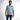 A man stands confidently in a light blue short-sleeve shirt with a textured graphic design, paired with jeans.