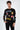 A model wearing a black long-sleeve shirt featuring colorful graphic designs and playful text elements.