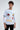 A model wearing a long-sleeve white shirt adorned with colorful graphics and playful text designs.