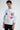 A model wearing a white long-sleeve shirt adorned with colorful graphics and playful text designs.