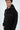 A young man wearing a black hoodie with a front pocket and subtle graphic detailing on the hood.