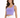A woman poses in a fitted, cropped purple top with a square neckline, paired with white high-waisted pants.