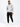 A man stands confidently in a light gray hoodie with a graphic design, paired with black cargo joggers and white snea...