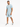 A man stands confidently in a light blue ribbed t-shirt and matching shorts, paired with white sneakers.