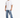 A man stands wearing a loose-fitting white t-shirt and light blue jeans, paired with white sneakers.