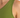 Close-up of a green sleeveless top, showcasing the smooth fabric and a relaxed fit around the shoulder area.