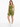 A model poses in a one-shoulder olive green crop top paired with matching bike shorts and white sneakers.