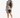 A man stands wearing a short-sleeve shirt and matching shorts with a bold black and white palm leaf pattern.