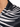 Close-up of a collared shirt featuring a black and white leaf pattern with a smooth, shiny fabric texture.