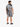 A man stands wearing a black and white palm leaf patterned short-sleeve shirt and matching shorts.