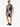 A man wearing a short-sleeve, palm-patterned shirt and matching shorts, paired with black sneakers.