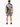 A man stands with his back to the camera, wearing a short-sleeve shirt and matching shorts featuring a black and whit...