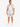 A man stands wearing a short-sleeve, light-colored shirt and matching shorts with a subtle palm leaf pattern.