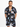 A man models a short-sleeve shirt with a colorful abstract pattern on a black background.