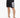 Black athletic shorts with a large white number graphic, paired with white sneakers and a casual fit.