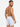 Male model wearing patterned swim shorts featuring colorful sailboat designs against a white background.