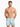 A man stands confidently in colorful swim trunks featuring a tropical palm tree print against a light background.