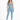 A woman stands confidently in a light blue one-shoulder crop top and matching leggings, paired with white sneakers.
