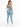 A woman in a one-shoulder, light blue bodysuit and leggings, viewed from the back, standing in white sneakers.