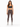 A woman stands confidently in fitted brown leggings paired with a dark sports bra and stylish sneakers.