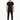 A man stands confidently in a fitted black t-shirt and slim black pants, paired with white sneakers.