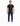 A man stands confidently in a fitted black t-shirt and navy pants with a chain detail, paired with white sneakers.